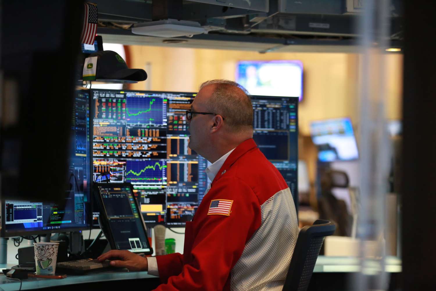 A trader at a bank of screens on an exchange floor