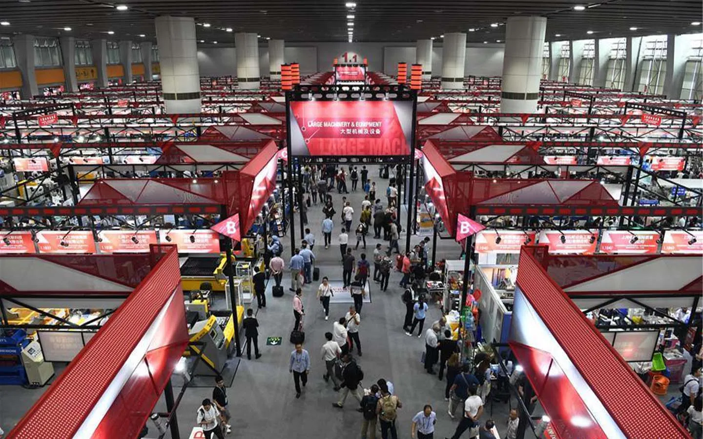 A hall of the China Import and Export Fair Complex in Guangzhou, under the fair's red livery and bilingual Large Machinery and Equipment signage