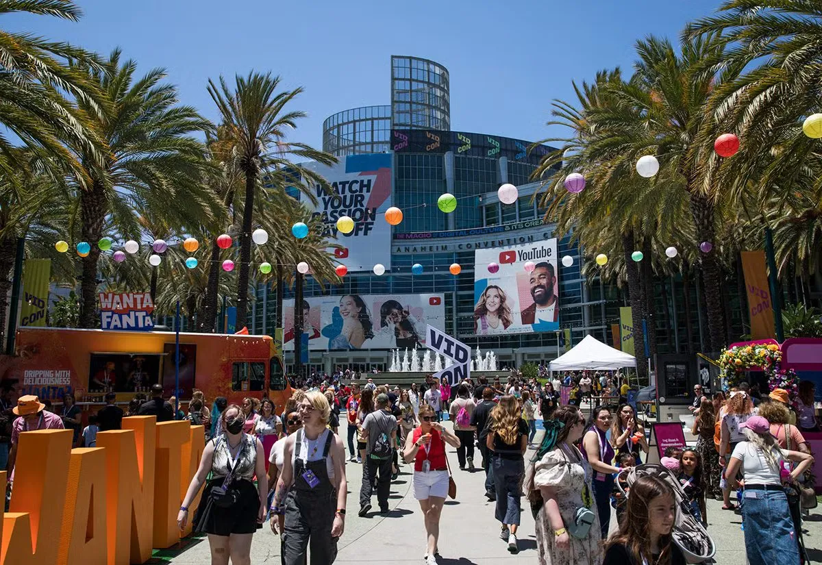 Crowds outside the Anaheim Convention Center under VidCon banners and palm trees at a previous edition